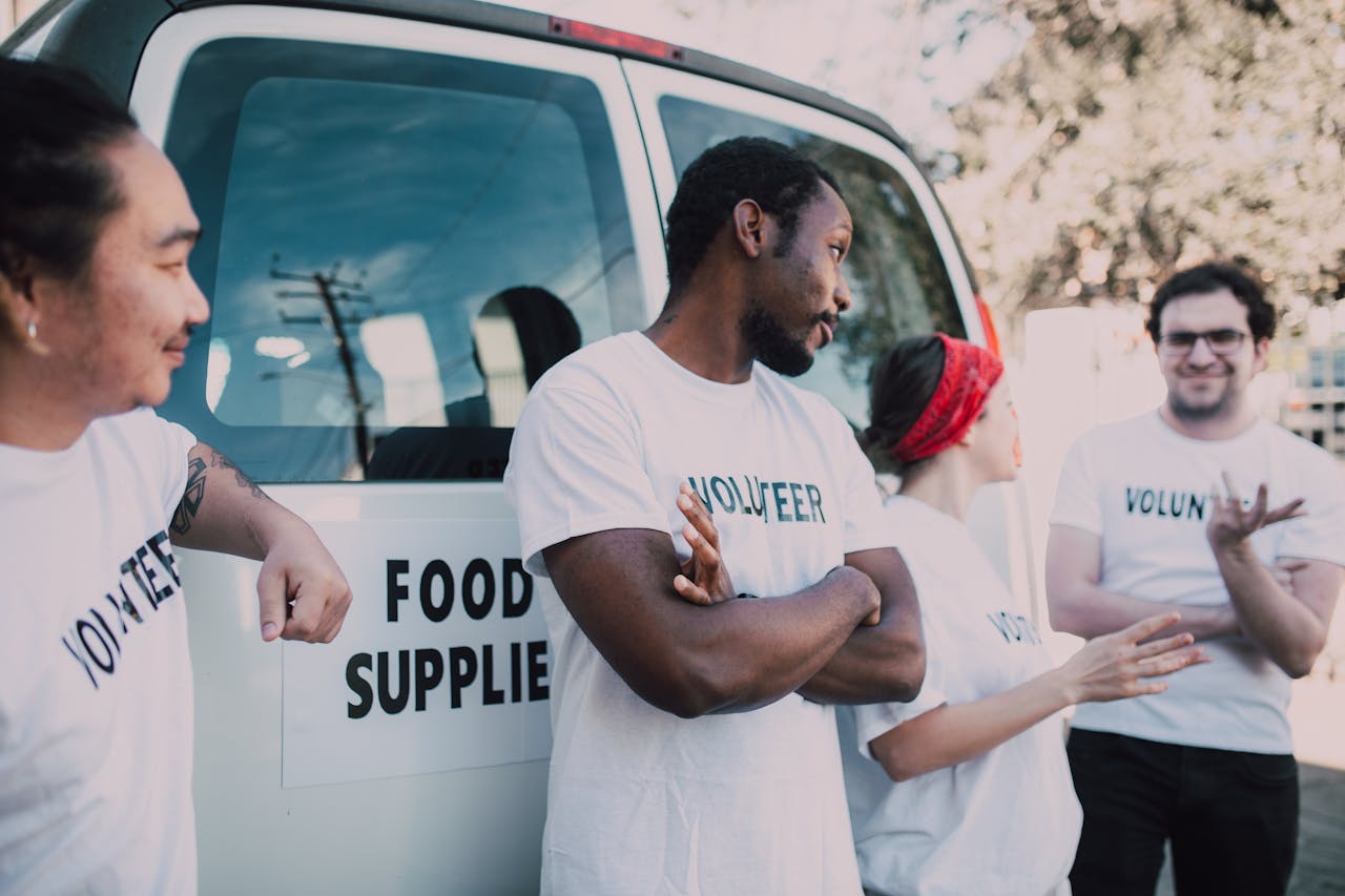 Crafting Captivating Headlines: Your awesome post title goes here Volunteers gather beside a van to prepare and distribute food supplies outdoors.